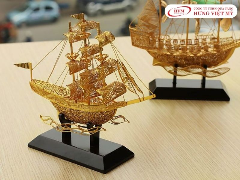 Thuyền buồm căng gió mạ vàng, tượng trưng "Thuận Buồm Xuôi Gió" và khát vọng vươn ra biển lớn.